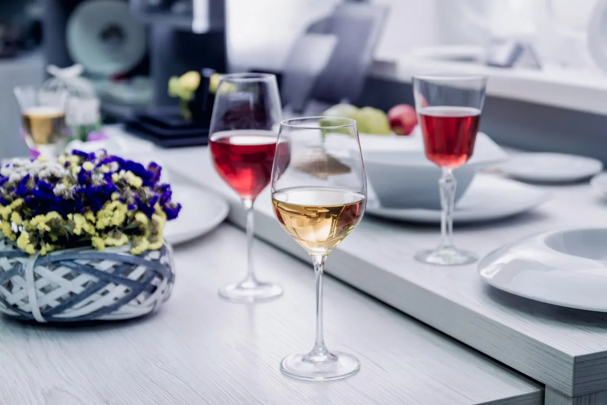 A glass of white wine and a glass of red wine, highlighting the experience of wine tours.